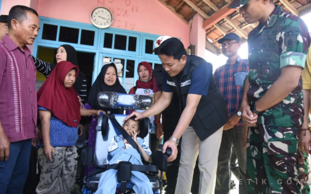Foto Bupati Subandi bersama Dandim Letkol Abraham Pribadi menyerahkan kursi roda untuk Nur Indah, bocah difabel di Tarik, Sidoarjo. (Foto: Mashud/Kominfo Sidoarjo.
