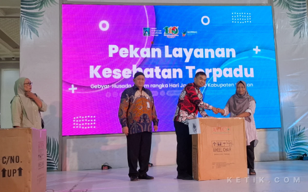 Foto Didampingi Kepala Dinas Kesehatan Kabupaten Sleman Cahya Purnama (kiri), perwakilan dari Dinsos Sleman menyerahkan secara simbolis bantuan kursi roda kepada warga pada penutupan Gebyar Husada 2026. (Foto: Fajar R/Ketik.com)
