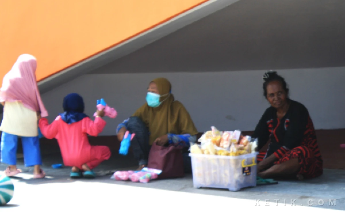 Foto Seorang pedagang asongan berjualan kerupuk  di dalam Alun-Alun Sidoarjo saat car free day pada 1 Februari lalu. Aturan melarang berjualan di dalam alun-alun. (Foto: Fathur Roziq/Ketik.com)